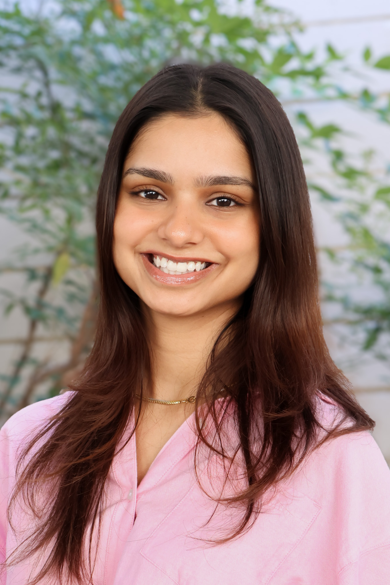 Woman smiling wearing a pink collar shirt
