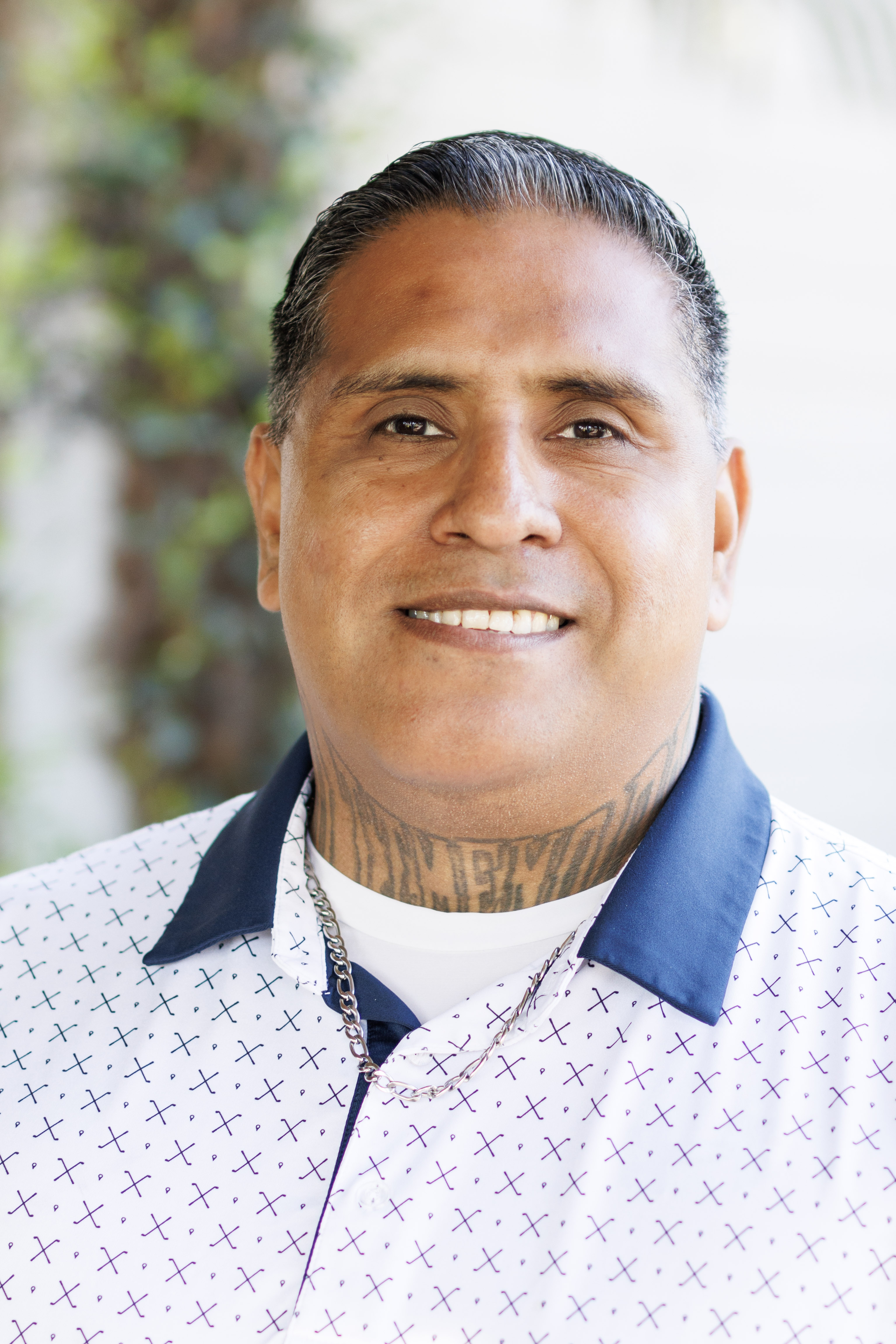 Smiling man in a sweater outdoors.