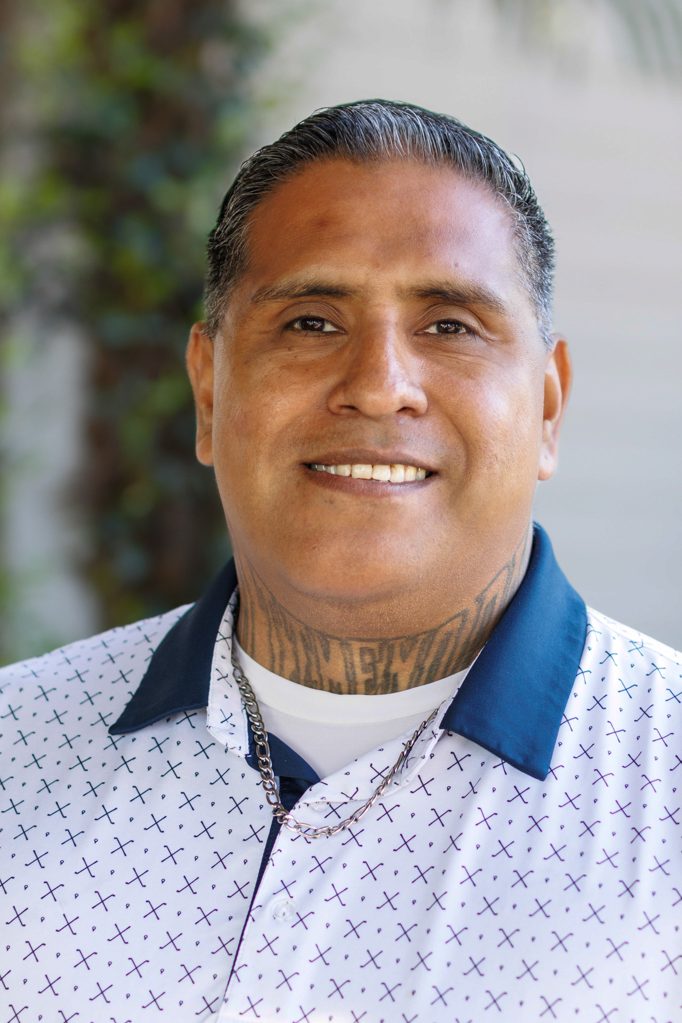Smiling man in a sweater outdoors.