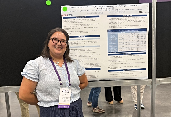 Jordan Kozuki stands next to her poster