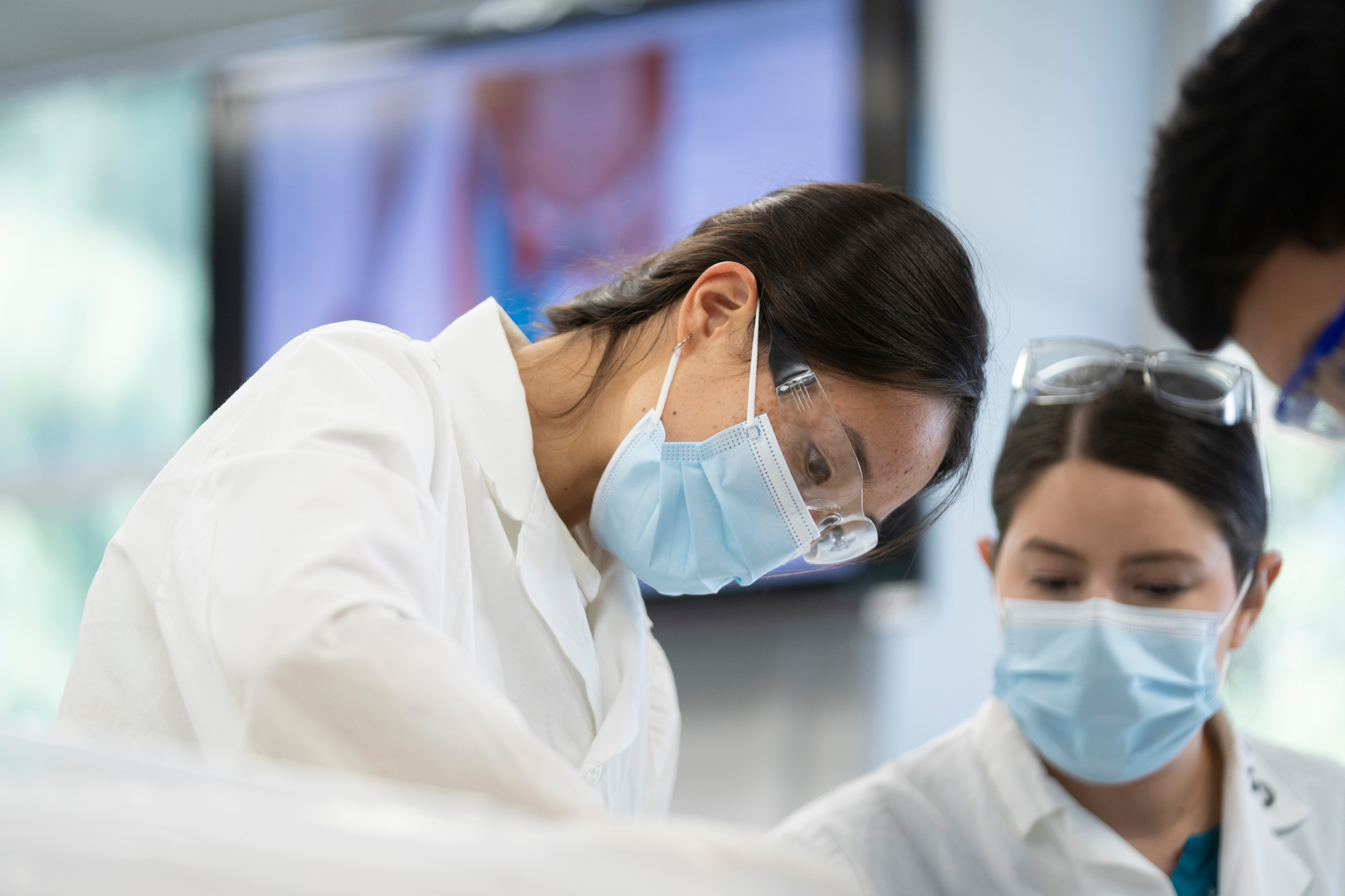 Photo of three people wearing protective eyeglasses and masks