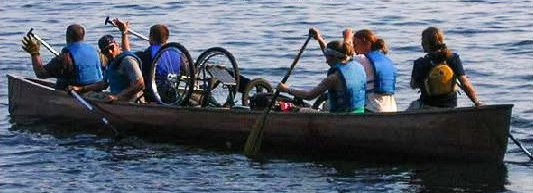 A group of people rowing a large canoe