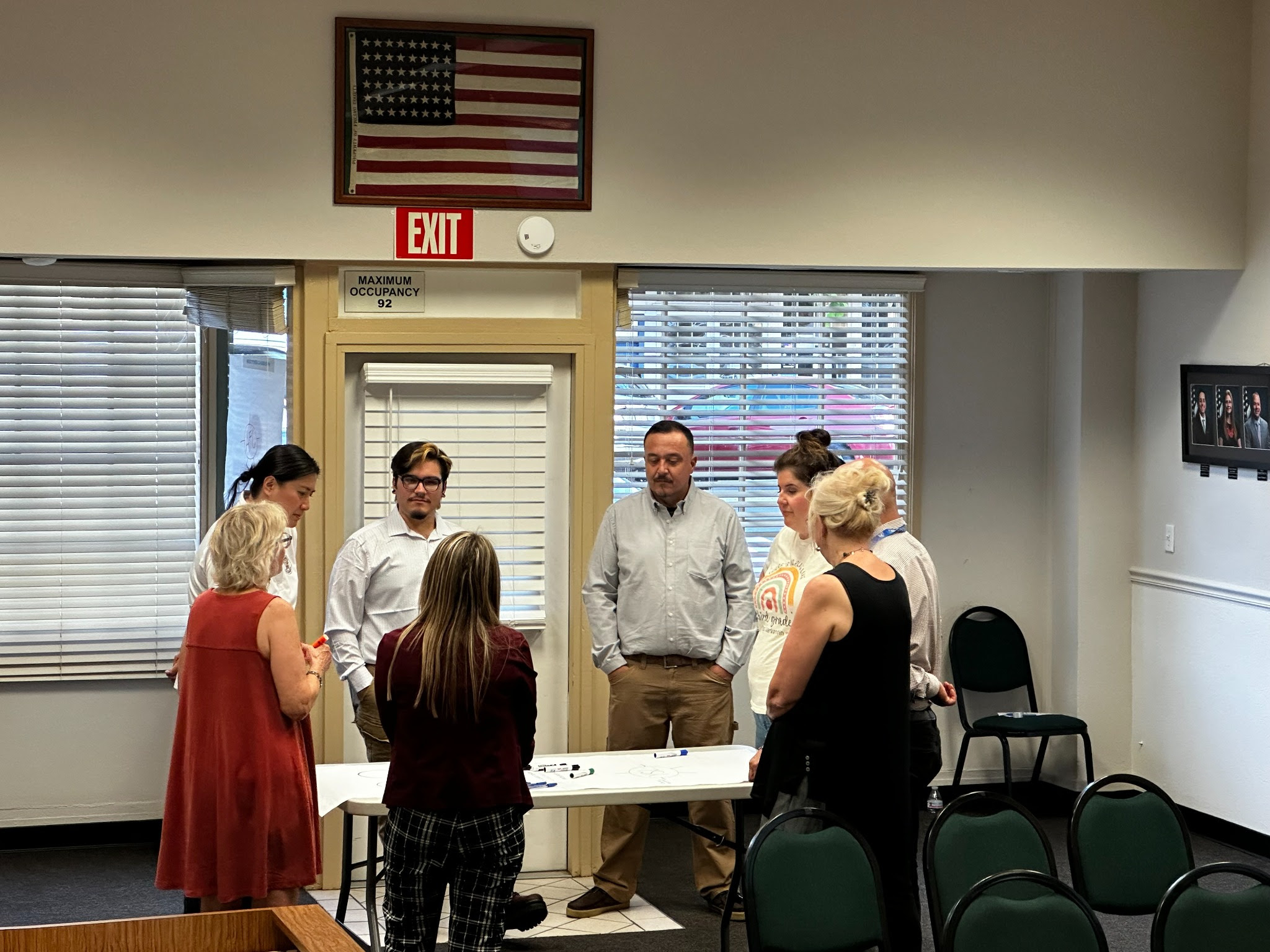 Students standing around table with Kingsburg city council members.