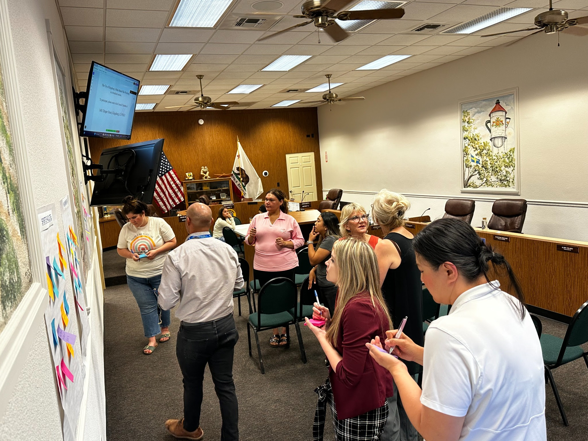 REC 77s students examining posters and charts on wall at Kingsburg city council meeting.