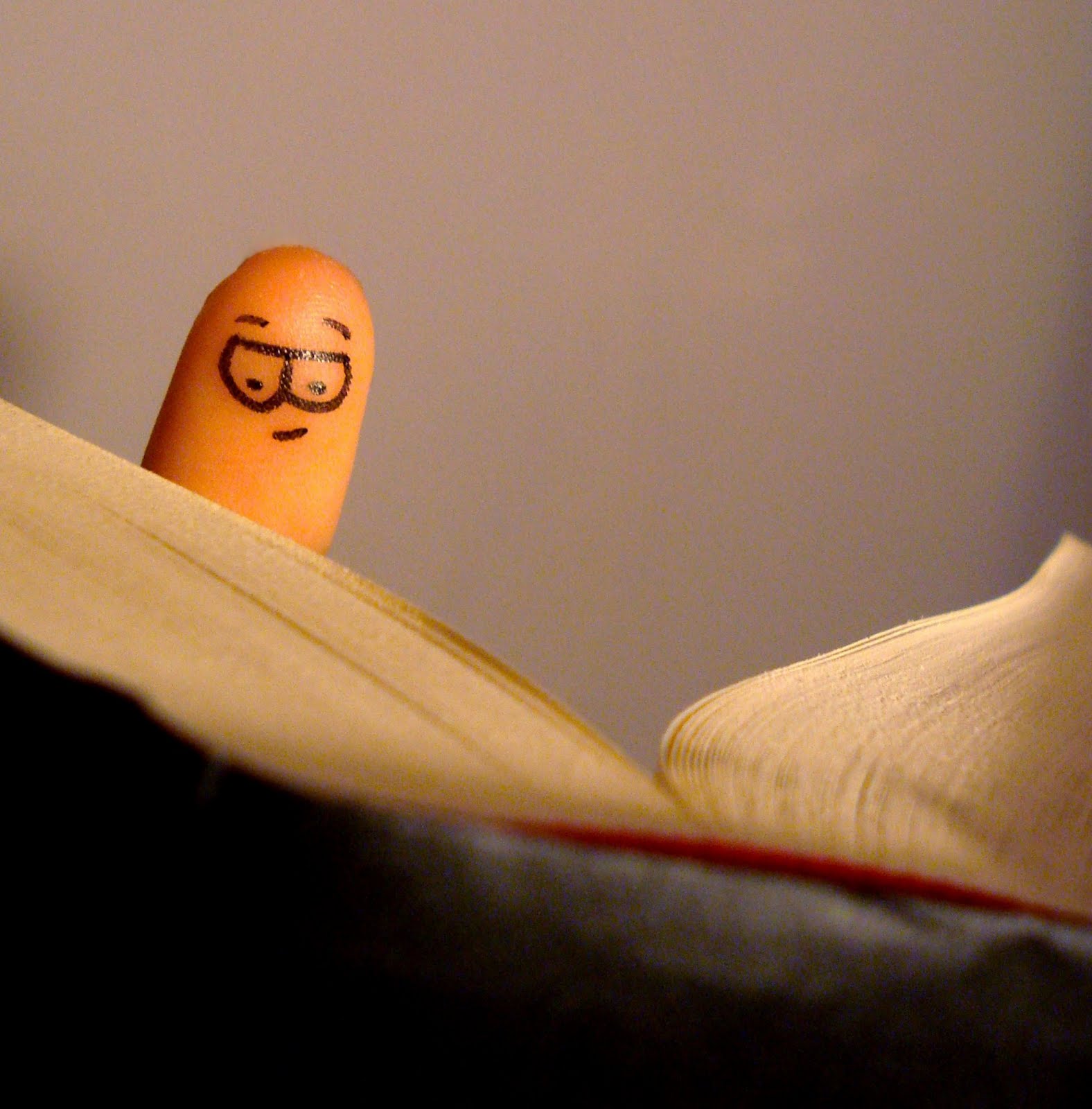 book being read by finger with face drawn on it