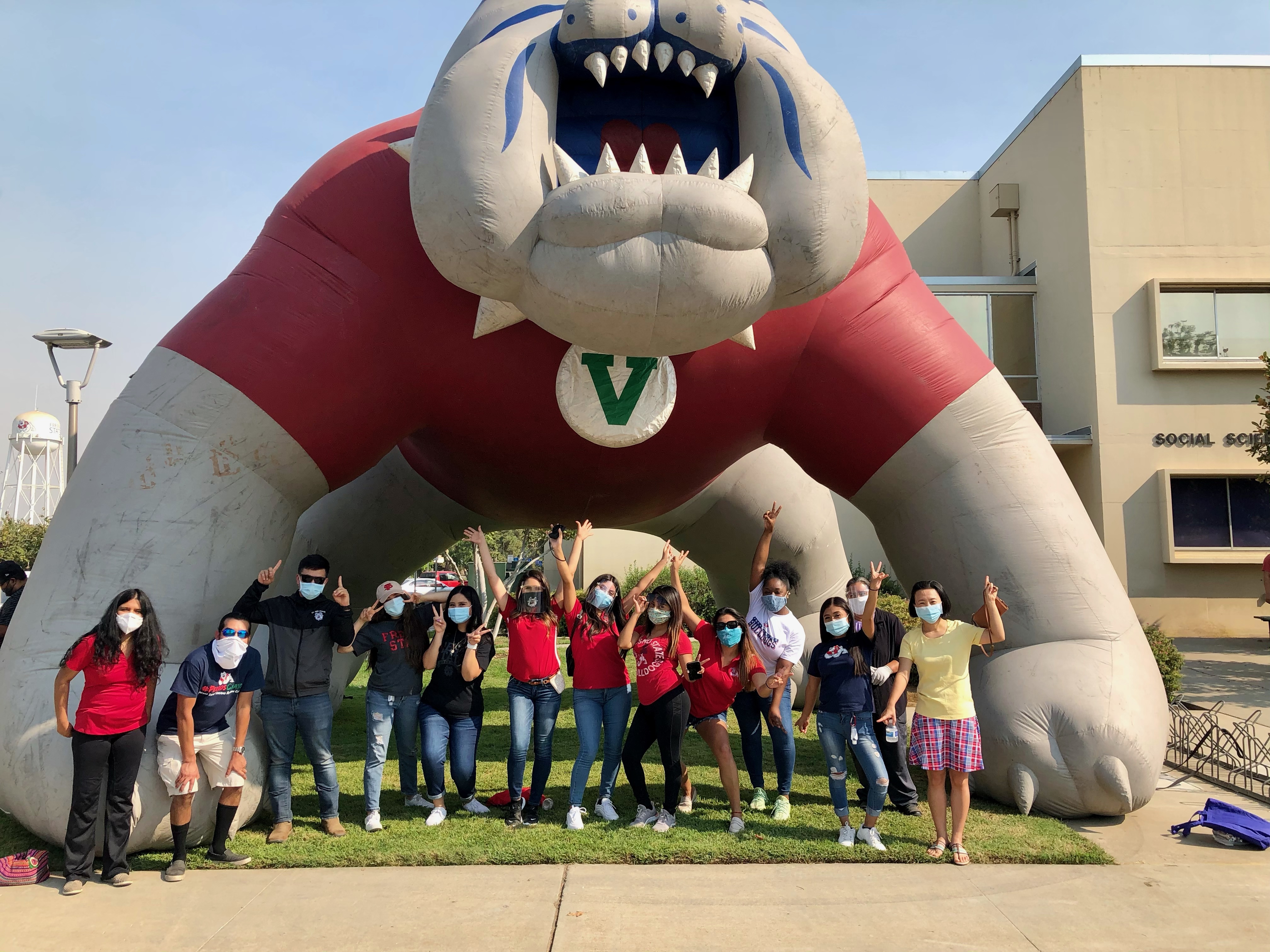 Student association members posing in front of inflatable bulldog mascot