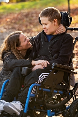 Cal Valcourt-Pearce smiles at her son who is in a wheelchair